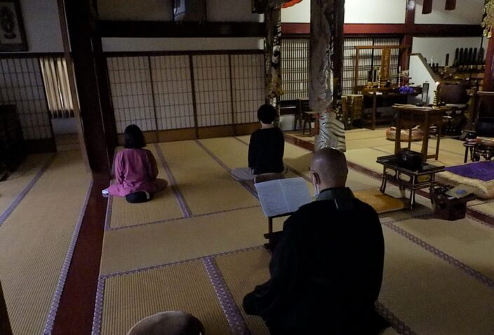 二名の参加者が本堂で坐禅をしている様子。外の天候に合わせて少しうす暗い本堂にて。